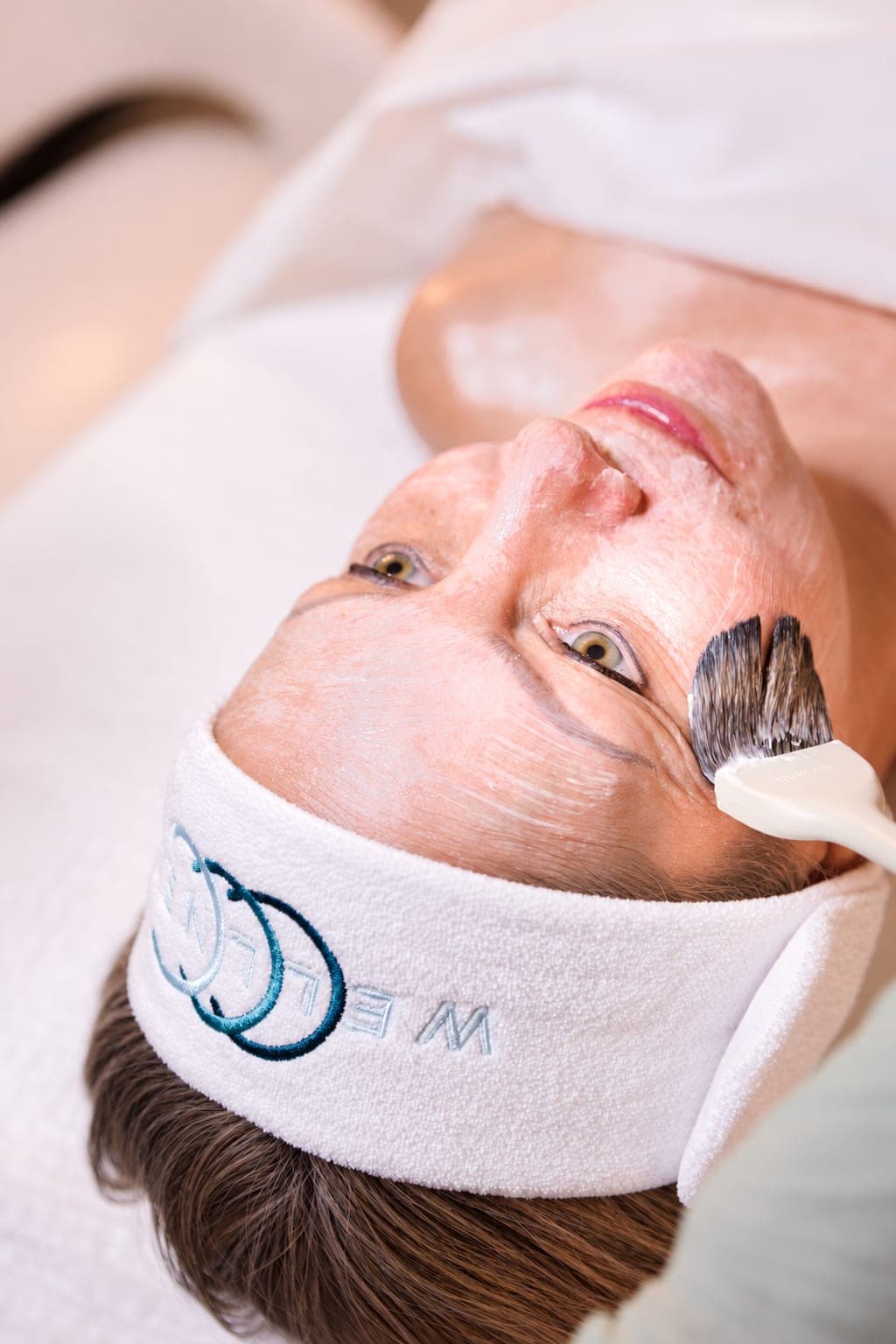 A client receives a facial at CCC Wellness, headband with the CCC Wellness mark visible